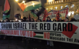 Anti-Israel protesters wave Palestinian flags and hoist a sign reading 'give Israel the red card' against Israeli participation in sporting events, outside a basketball game between Virtus Bologna and Maccabi Tel Aviv in Bologna, Italy, November 21, 2025. (Screen capture: Il Fatto Quotidiano)